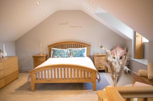 a bedroom with a wooden bed and wooden furniture at Vineyard Country Cottage in Llanerch-Aeron