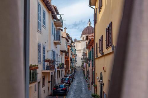 an alley with cars parked on a street between buildings at Casa Matta in Castel Gandolfo