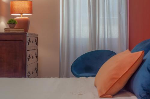 a bedroom with a bed with two blue chairs and a lamp at Casa Matta in Castel Gandolfo