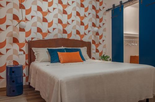 een slaapkamer met een bed met een oranje en witte muur bij Casa Matta in Castel Gandolfo