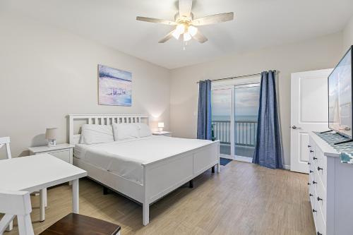 ein weißes Schlafzimmer mit einem Bett und einem Fenster in der Unterkunft Las Joyas Bayview Home in Port Isabel