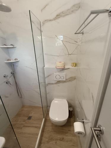 a white bathroom with a toilet and a shower at Cyclades Studios in Parikia