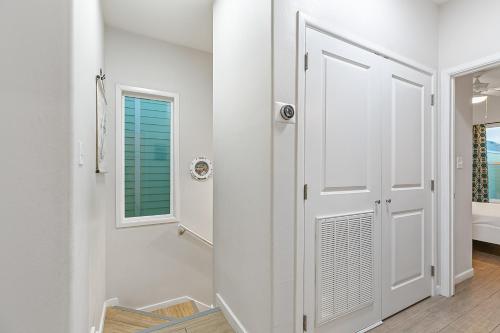 a white hallway with a door and a window at Las Joyas Bayview Home in Port Isabel