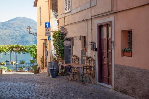 an alley with a table and chairs on a street at Casa Matta in Castel Gandolfo