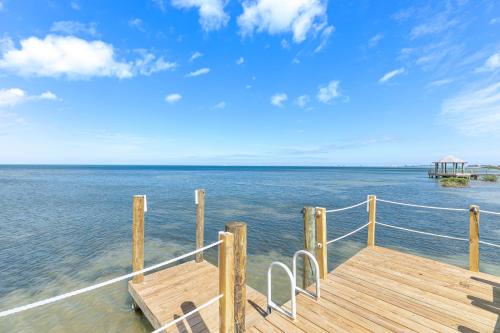 a wooden dock with a view of the water at Las Joyas Bayview Home in Port Isabel