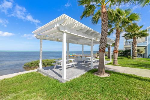 a picnic shelter on the beach with palm trees at Las Joyas Bayview Home in Port Isabel