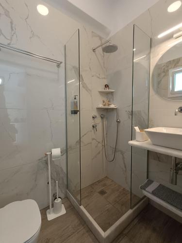 a bathroom with a shower and a toilet and a sink at Cyclades Studios in Parikia
