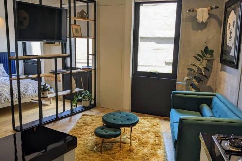 a living room with a blue couch and a stool at A Hip Modern Gem in El Centro! in Mexico City