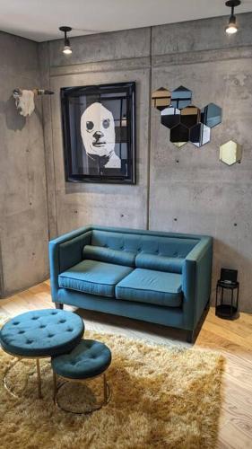 a living room with a blue couch and a stool at A Hip Modern Gem in El Centro! in Mexico City
