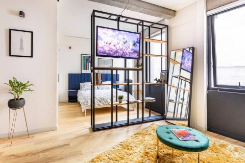 a living room with a tv and a bed in a room at A Hip Modern Gem in El Centro! in Mexico City