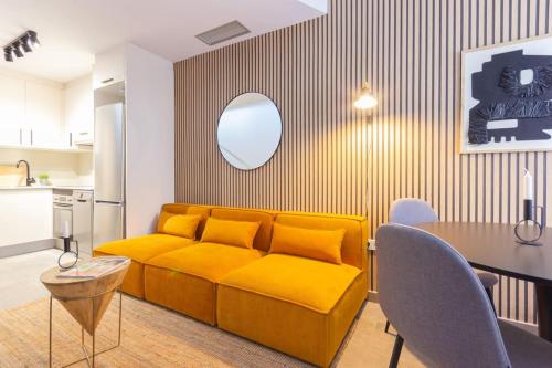 a living room with a yellow couch and a table at Duplex with terrace near Bcn in Terrassa