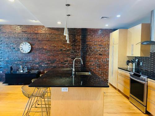 a kitchen with a sink and a brick wall at Boston North end Harbor View condo. FREE PARKING in Boston