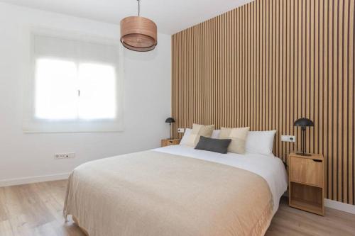 a bedroom with a large bed and a window at Duplex with terrace near Bcn in Terrassa