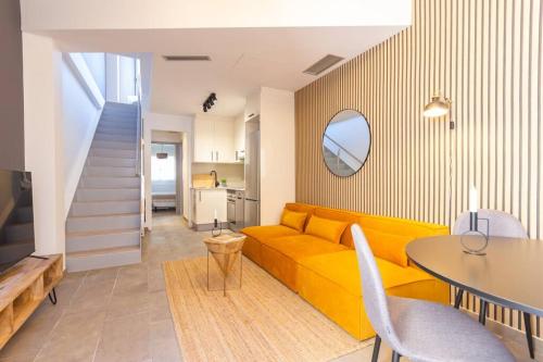 a living room with a yellow couch and a table at Duplex with terrace near Bcn in Terrassa