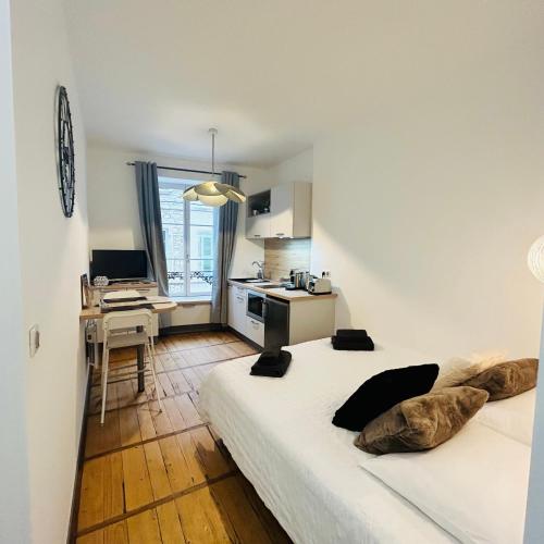 Cette chambre comprend un lit, un bureau et une cuisine. dans l'établissement Studio Carnot - Centre - Climatisation, à Beaune