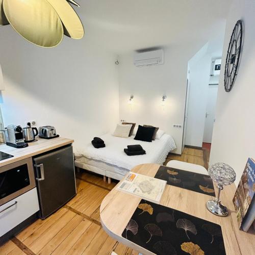 Ce petit appartement comprend un lit, une table et une cuisine. dans l'établissement Studio Carnot - Centre - Climatisation, à Beaune