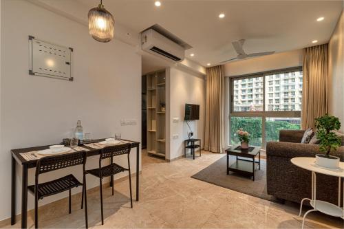 a living room with a couch and a table at One Bedroom Apartment - Regent Hills, Mumbai Powai in Mumbai