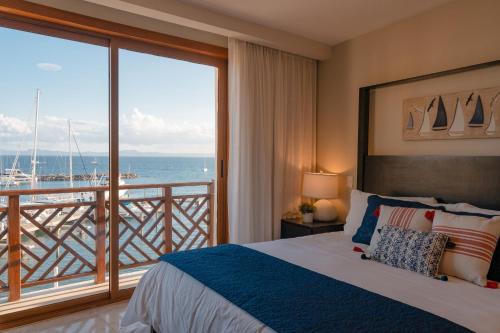 a bedroom with a bed and a view of the ocean at The Bannister Hotel & Yacht Club by Mint in Santa Bárbara de Samaná