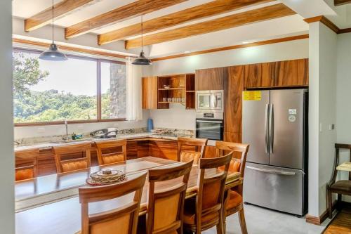 eine Küche mit Tisch und Edelstahlkühlschrank in der Unterkunft Cloud Forest House Monteverdes in Monteverde Costa Rica