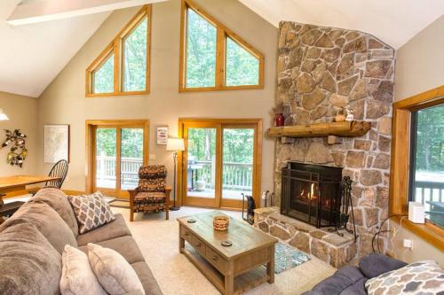 a living room with a large stone fireplace at Forest Ridge @ Deep Creek Lake in Oakland