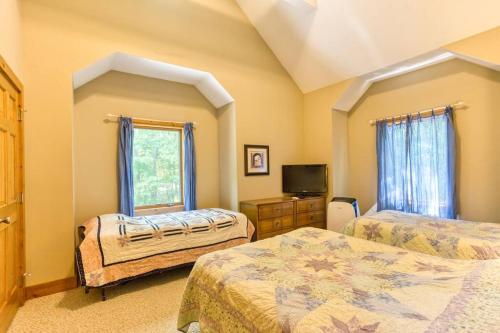 a bedroom with two beds and a tv in it at Forest Ridge @ Deep Creek Lake in Oakland