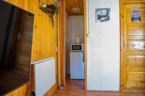 eine Küche mit einem weißen Kühlschrank und einer Tür in der Unterkunft Mountain VISTA, Bușteni in Buşteni