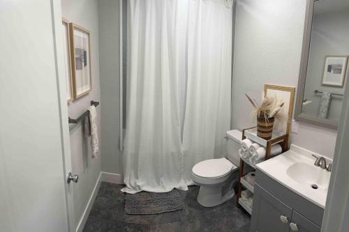 a bathroom with a white shower curtain and a toilet at Studio with Private Beach on Bayou Grande in Pensacola