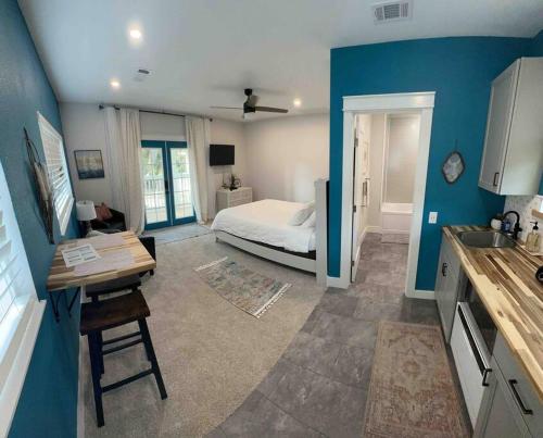 a bedroom with a bed and a kitchen with a table at Studio with Private Beach on Bayou Grande in Pensacola