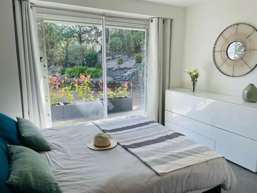 a bedroom with a bed with a hat and a window at Villa Les Sorbiers in La Baule