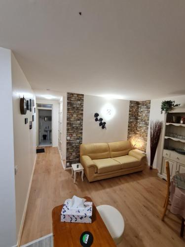 sala de estar con sofá y mesa en Deux pièces terrasse, en Moret-sur-Loing