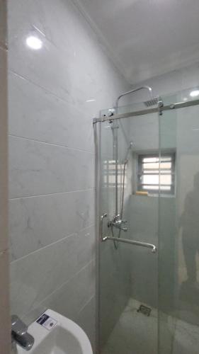 a bathroom with a glass shower with a toilet at Contemporary 1 bedroom apartment in awoyaya ibeju lekki in Awoyaya