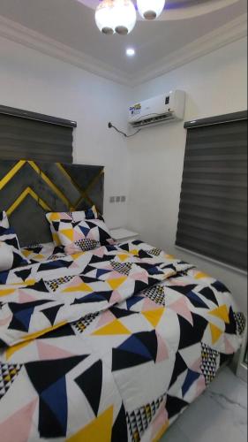 ein Schlafzimmer mit einer Bettdecke und Kissen auf einem Bett in der Unterkunft Contemporary 1 bedroom apartment in awoyaya ibeju lekki in Awoyaya