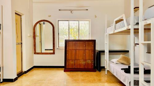 a room with two bunk beds and a mirror at Mitra Hostel (By The Pool) in Vagator