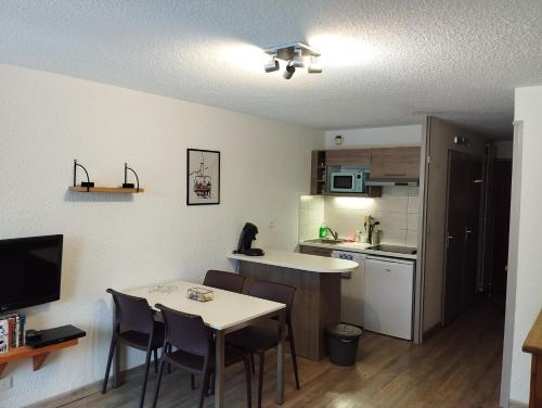 Appartement idéalement situé في سا شيفري: مطبخ صغير مع طاولة وكراسي في الغرفة