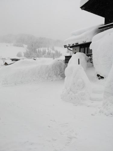 a pile of snow on the side of a house at Appartement Seebacher in Hochfilzen