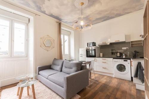 un salon avec un canapé et une cuisine dans l'établissement Immeuble L'aristocrate - Le Nuage - Bd Carnot, à Angers