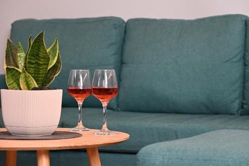 dos copas de vino en una mesa delante de un sofá en Zoe's Suite Athen's Center, en Atenas