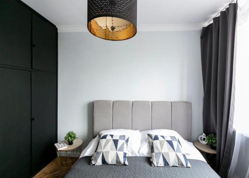 sypialnia z łóżkiem z szarym zagłówkiem w obiekcie Nowogrodzka 78 - Apartament dla 4 osób - 200m od Szpitala Klinicznego na Lindleya - 1km do Dworca Centralnego - Wifi - Smart TV 45 cali w Warszawie