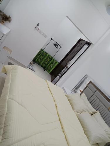 a white bed with pillows in a room at Kayan aprtment2 in Muscat
