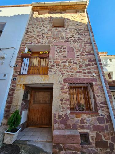 a brick building with two windows and a wooden door at Casa Turistica Torreón de Villafamés in Villafamés