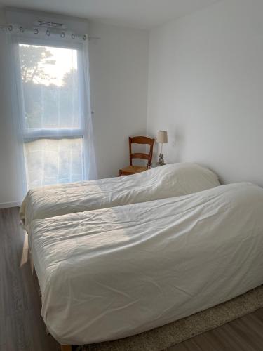 een bed in een slaapkamer met een raam bij À 2 pas de la plage in Saint-Pierre-Quiberon