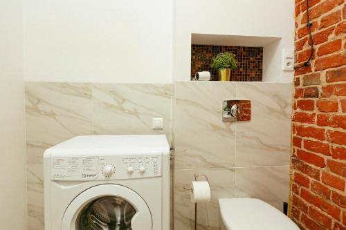 a bathroom with a washer and dryer next to a toilet at Wspólna 54a - Bezpłatny parking - Apartament dla 6 osób - 450 metrów od Dworca Centralnego i Złotych Tarasów - Better Rental in Warsaw
