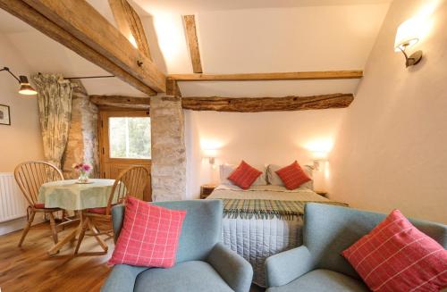 1 dormitorio con 1 cama, mesa y sillas en Hayloft studio in historic barn, en Saint Briavels