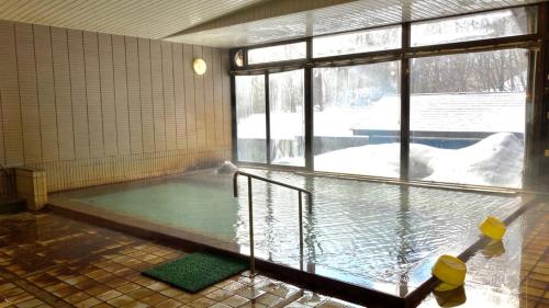a room with a pool of water with a window at Mori no RyoTei Mount Bandai - Vacation STAY 43099 in Numajiri