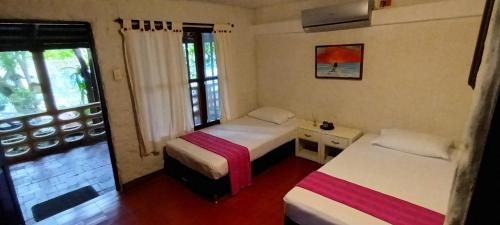 a bedroom with two beds and a window at Villa Margarita in Puerto Colombia
