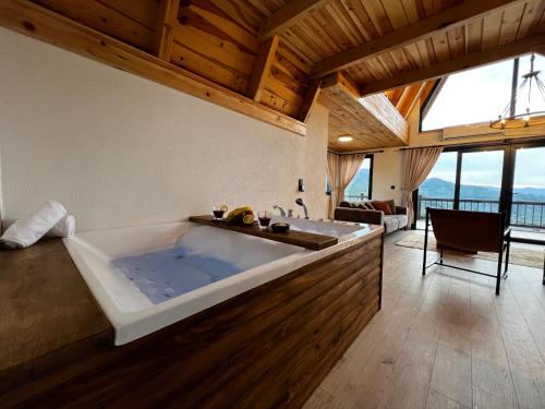 a large bath tub in a room with a table at Meona Villa Bungalov in Ardeşen
