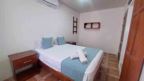 a bedroom with a bed with two towels on it at Casa THIREMA Tortuguero in Tortuguero
