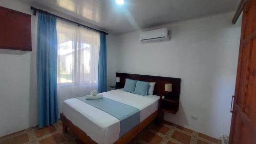 a bedroom with a large bed with a window at Casa THIREMA Tortuguero in Tortuguero
