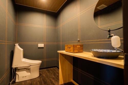 a bathroom with a sink and a toilet and a mirror at InnCocoSumu？ - Vacation STAY 03071v in Kirishima