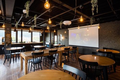 a restaurant with wooden tables and chairs and a screen at InnCocoSumu？ - Vacation STAY 03071v in Kirishima